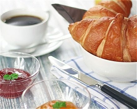 A table with coffee and a croissant